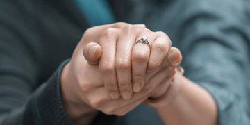 two hands showing off an engagement ring