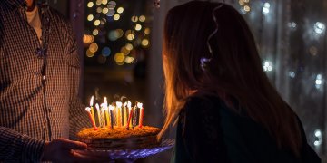 person blowing out birthday cake candles